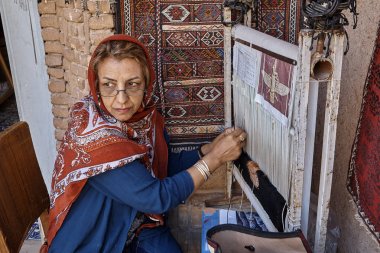Bir İranlı kadın Farsça halı el örgüleri.