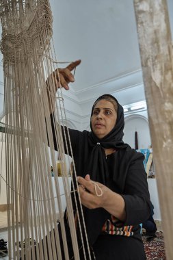 Bir İranlı kadın weaver Farsça halı yapım Atölyesi, Yazd.