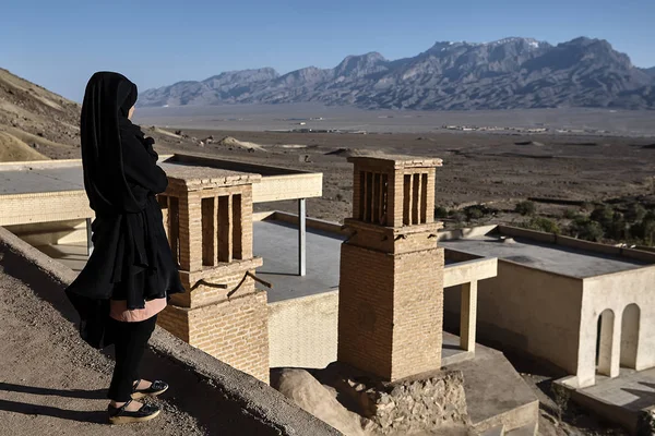 Una chica en chador negro mira a las montañas, Yazd, Irán . —  Fotos de Stock