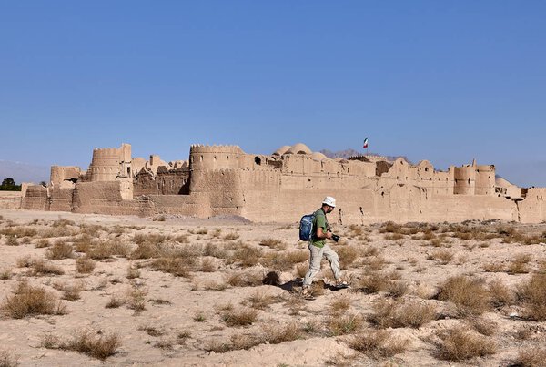 Photographer traveler goes to ancient fortress Saryazd near Yazd in Iran.