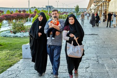 Isfahan, İran'daki Naghshe Cihan Meydanı çevresinde İran aile yürür.