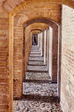 Antik taş kemerli Khaju Köprüsü'nde, Isfahan, Iran.