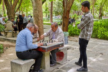 Elderly Iranians play chess in the park, Isfahan, Iran. clipart