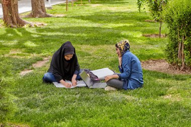Kızlar Park, Isfahan, Iran'ın bahçesinde sınıfları için hazırlanıyorlar.