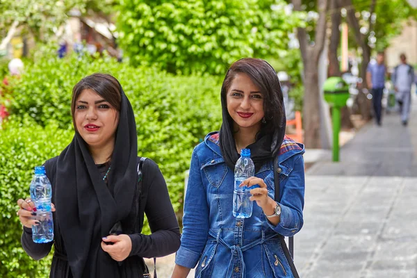 Иранские девушки пьют воду из бутылок во время прогулки, Исфахан, Иран . — стоковое фото