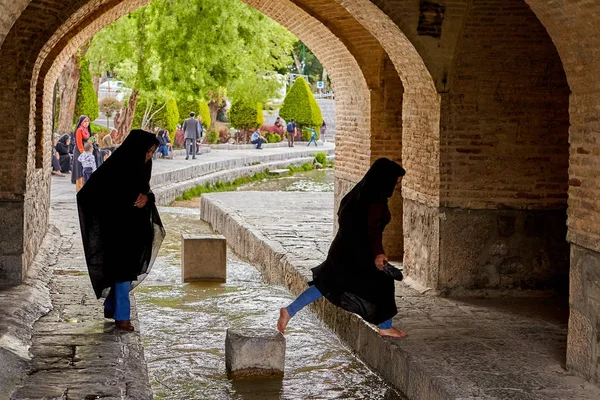 Chicas iraníes pisan el flujo de agua bajo el puente, Isfahán . — Foto de Stock