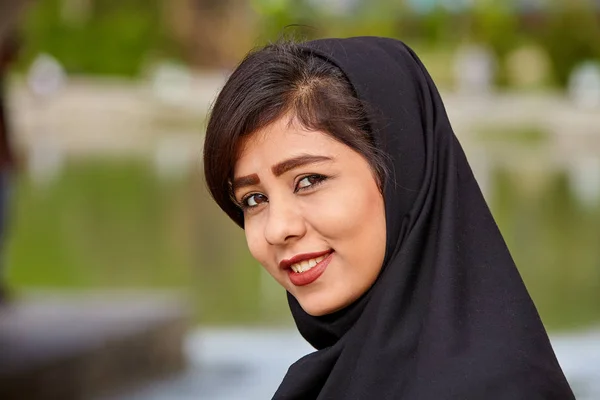 Портрет улыбающейся иранской девушки в чёрном хиджабе, Исфахан, Иран . — стоковое фото