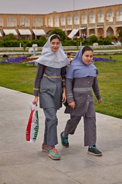 Isfahan, Iran - 24 Nisan 2017: hijabs'de iki İranlı kız okuduktan sonra parkta yürüyorlar.