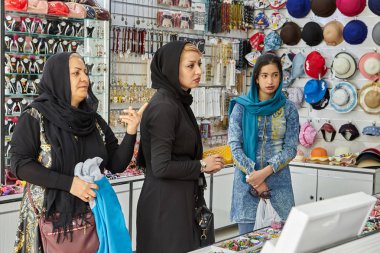Isfahan, Iran - 24 Nisan 2017: İranlı kız, kadın ve yaşlı kadın mağaza şapka ve takı Satıyoruz.