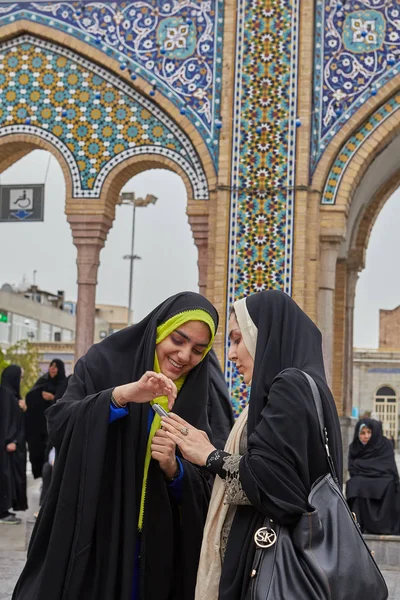 Mulheres iranianas assistir fotos em smartphones perto da mesquita, Teerã, Ir — Fotografia de Stock