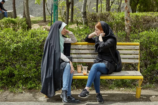 Due donne iraniane stanno parlando in panchina, Teheran, Iran . — Foto Stock