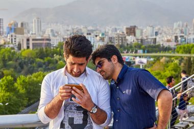 İki İranlı adam akıllı telefon ekranında, Tahran, Iran resimleri tarama vardır.