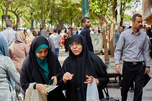 Két muszlim nők beszélnek a forgalmas utcán, Teherán, Irán. — Stock Fotó