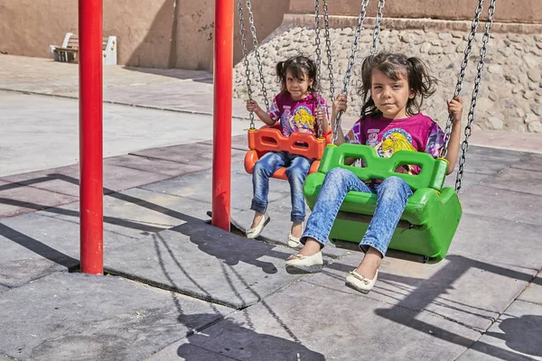 Dos niñas gemelas iraníes en un columpio, Kashan, Irán . — Foto de Stock