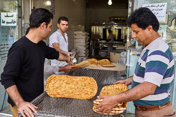 Иранские мужчины покупают лепешки у пекаря, Кашан, Иран . — стоковое фото