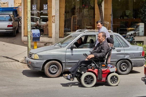 Hombre discapacitado sentado en un scooter de movilidad, Kashan, Irán . — Foto de Stock