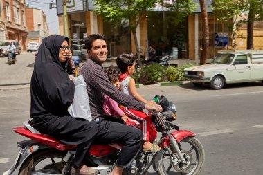İran aile rides bir motosiklet üzerinde işlek cadde,: Kashan, Iran.