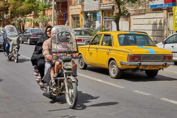 Familia iraní en una motocicleta en la calle concurrida, Kashan, Irán . — Foto de Stock