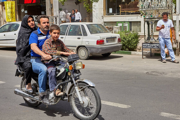 Мужчина возит жену и сына на мотоцикле, Кашан, Иран
.