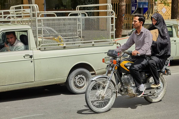 Pareja está montando una moto en la calle concurrida, Kashan, Irán . — Foto de Stock