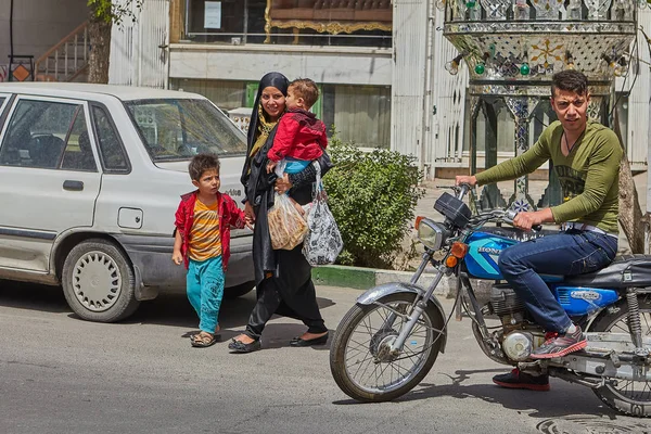 Mulher com crianças cruzando estrada na frente de moto, Kashan, Irã . — Fotografia de Stock