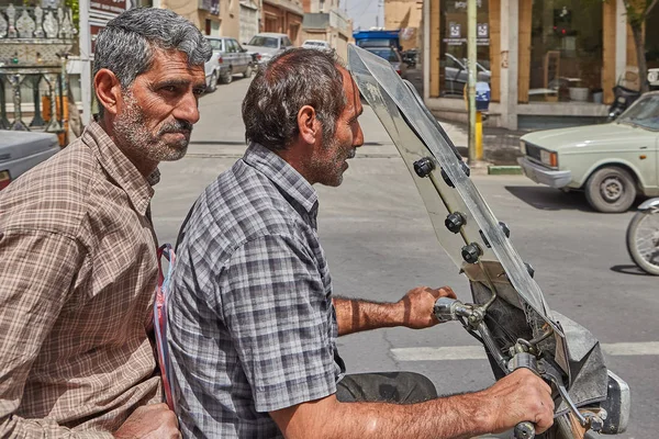 Närbild av två mogna män på en motorcykel, Kashan, Iran. — Stockfoto