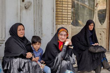 Otobüs durağı,: Kashan, Iran oturan çocuk ile Müslüman kadınlar.