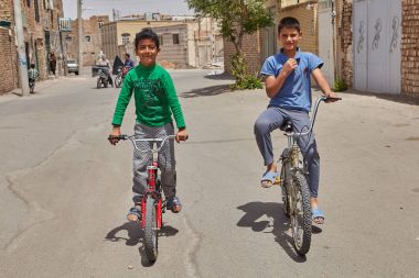 Çocuklar binmek bisiklet düşük katlı yerleşim bölgesinde: Kashan, Iran