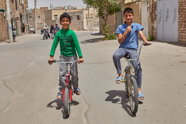 Jongens rijden op de fiets in laagbouw-woonwijk, Kashan, Iran — Stockfoto