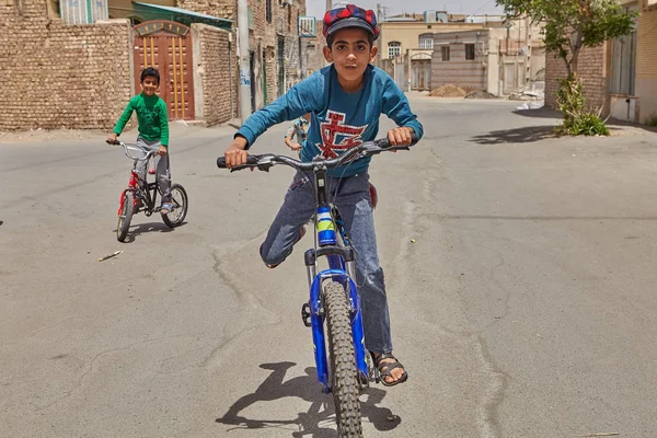 Jongen is fietsen in tuin met vrienden, Kashan, Iran. — Stockfoto