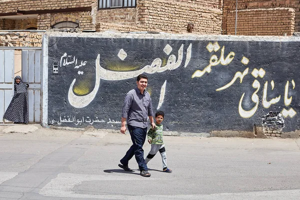 Far och son vandrar längs gatan, Kashan, Iran. — Stockfoto