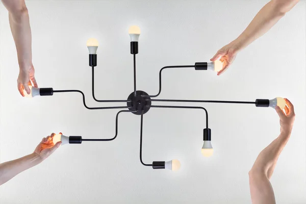 Kollegen vereinten Teamarbeit beim Schrauben neuer LED-Lampen — Stockfoto