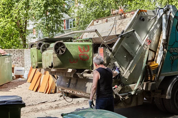 Los manitas vacían botes de basura en un camión de basura . — Foto de Stock