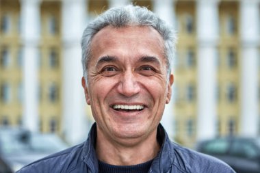 50 yaşını geçmiş neşeli, başarılı, zeki bir adam..