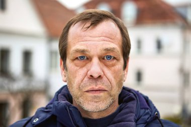 Orta yaşlı beyaz bir adamın somurtkan yüzü..