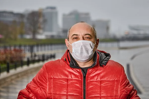 Άνδρας με ζεστά ρούχα και ιατρική μάσκα σε εξωτερικούς χώρους. — Φωτογραφία Αρχείου