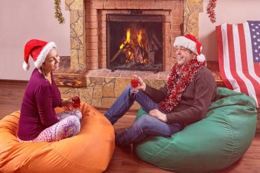 Bir çift Noel 'i şöminenin yanında kutluyor..