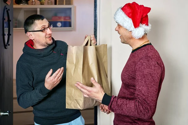 Man gives guest package with Christmas present.