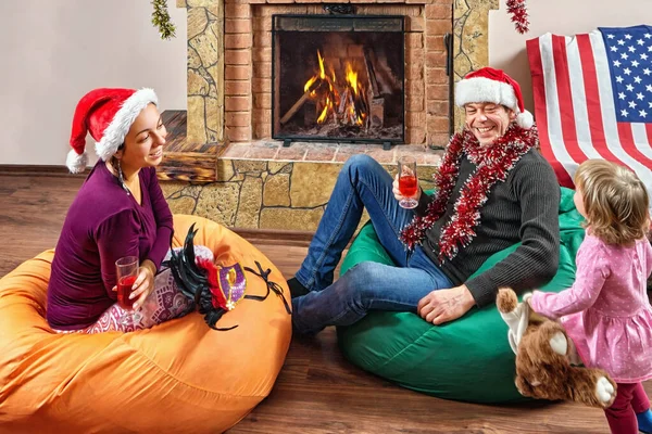 Cheerful family celebrates Christmas near fireplace.