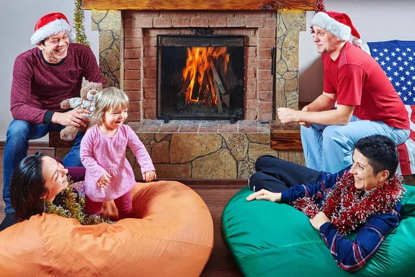 Big family celebrates New Year near fireplace.