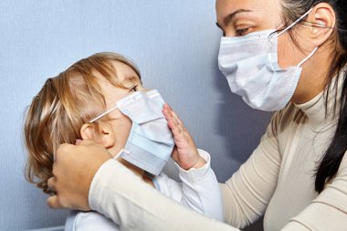 Anne ve kızı tıbbi maske takıyor..
