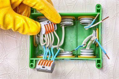 Cables are spliced inside an electrical box. clipart