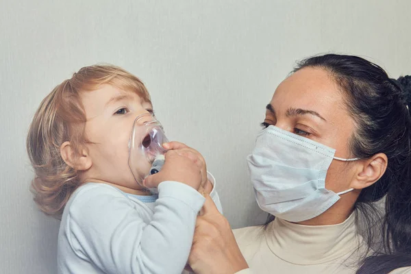 Mother helps child to breathe with mask. — Stock Photo, Image