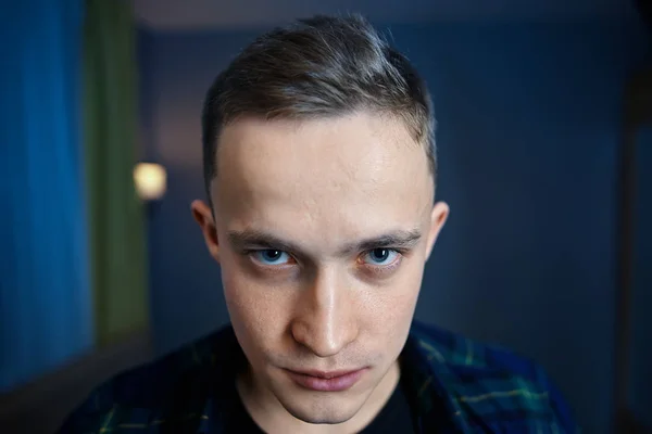 Embittered young man in a dark room, close-up face — Stock Photo, Image