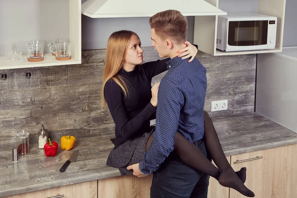 Jóvenes amantes se abrazan en la cocina . —  Fotos de Stock