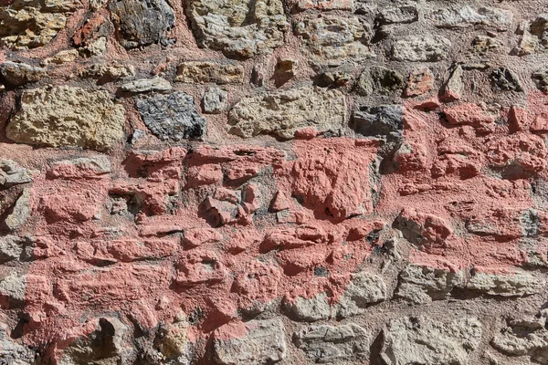 粘土モルタルの粗い石積み 石壁の表面の質感と赤絵具のストリップ 背景の抽象的なイメージ — ストック写真