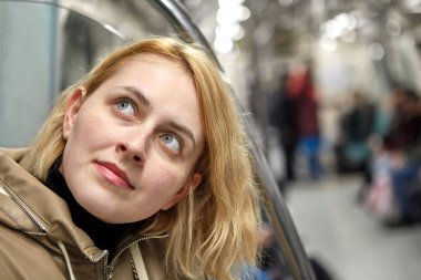 Sarışın beyaz, güzel, beyaz bir kadın İstanbul 'da metro vagonunda oturuyor..