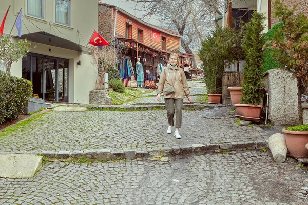 若いですかなり白髪ブロンドの女性レインコートでイスタンブールの歴史的中心部の通りを夜明け歩いています トルコ — ストック写真