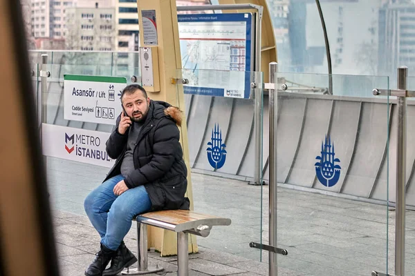 トルコのイスタンブール 2020年2月12日 男性の乗客が地下鉄の駅のベンチに座って携帯電話で話している — ストック写真