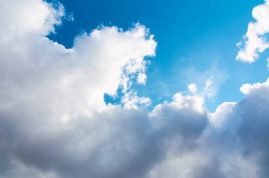 Güneş gündüz vakti gökyüzünde bir bulutun arkasında saklanıyor..